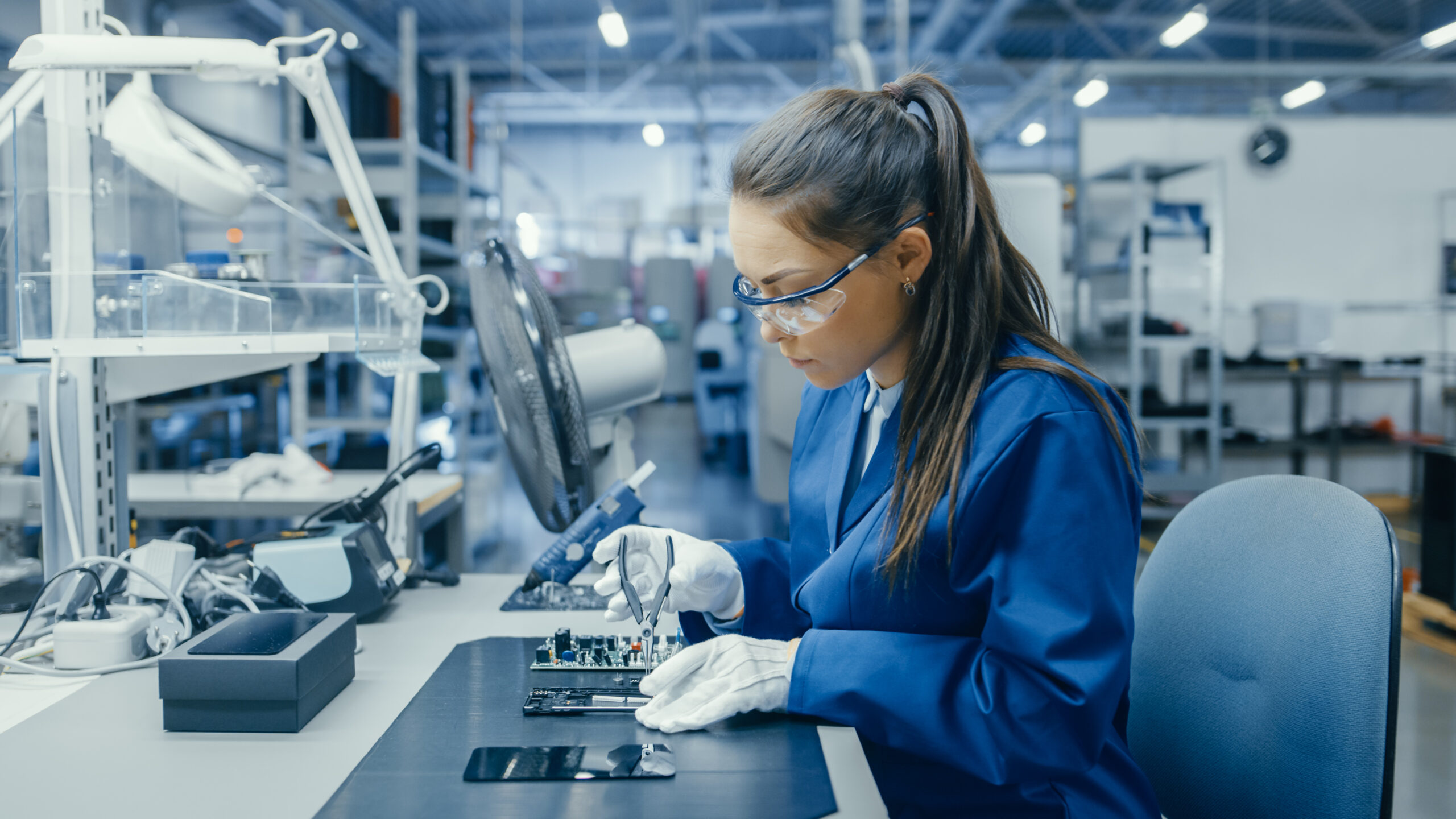 Engineer assembling electronic components in a high-tech manufacturing environment