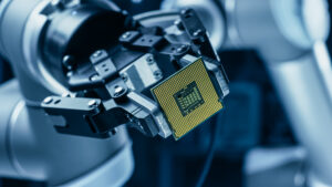 Robotic arm holding a semiconductor chip in an industrial environment