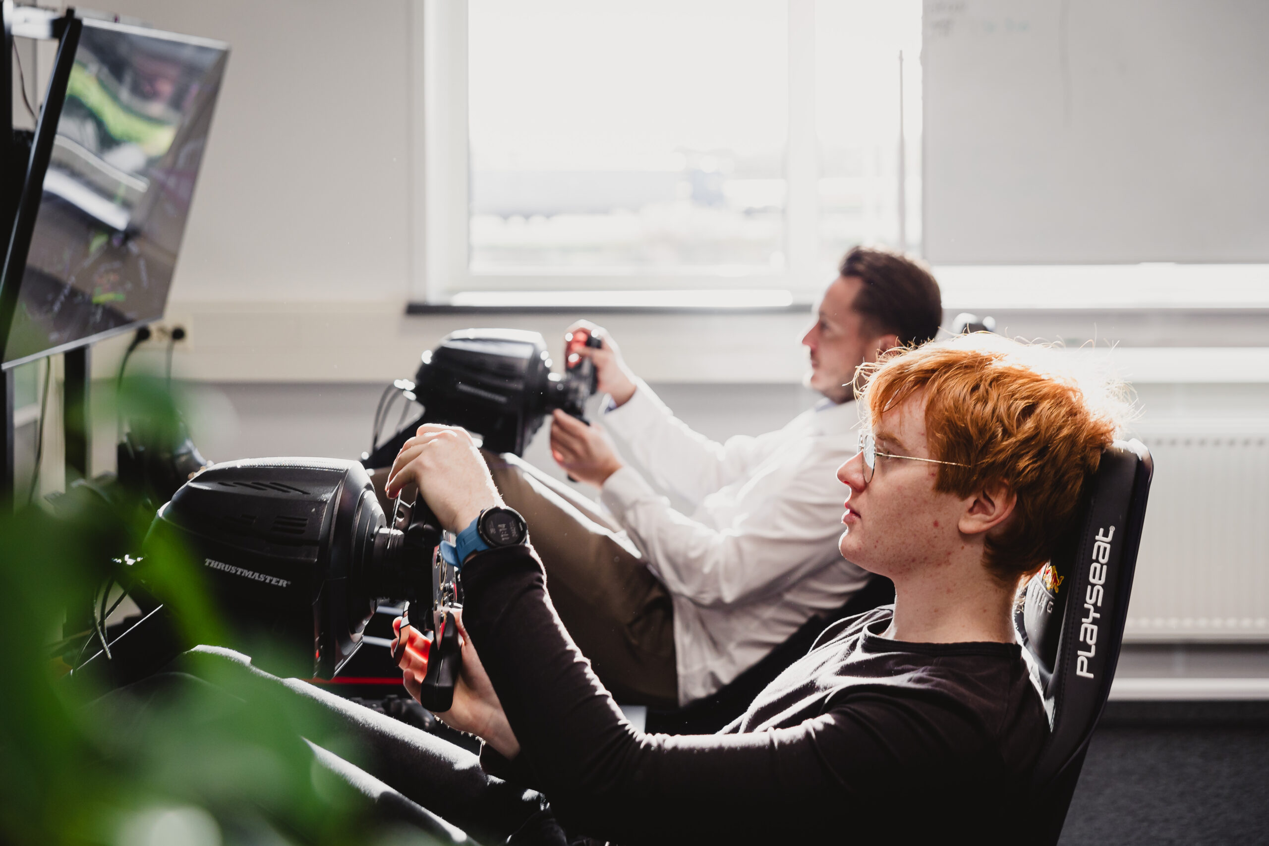 Two people in a race simulator.