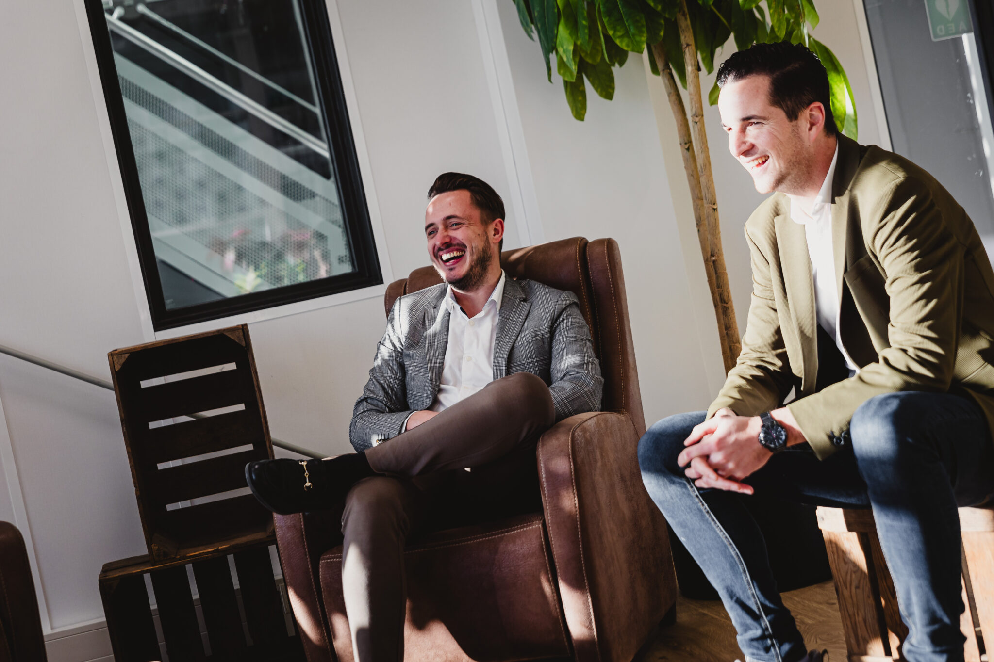 Two people sitting in a chair, laughing.