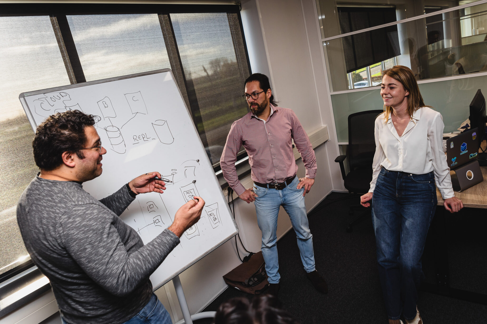 Three people around a whiteboard.