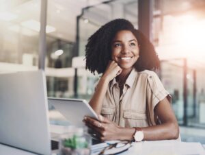 Professional working on a laptop and tablet in a modern office environment