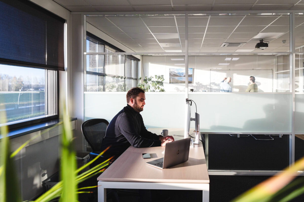 Person sitting at a desk behind a computer.