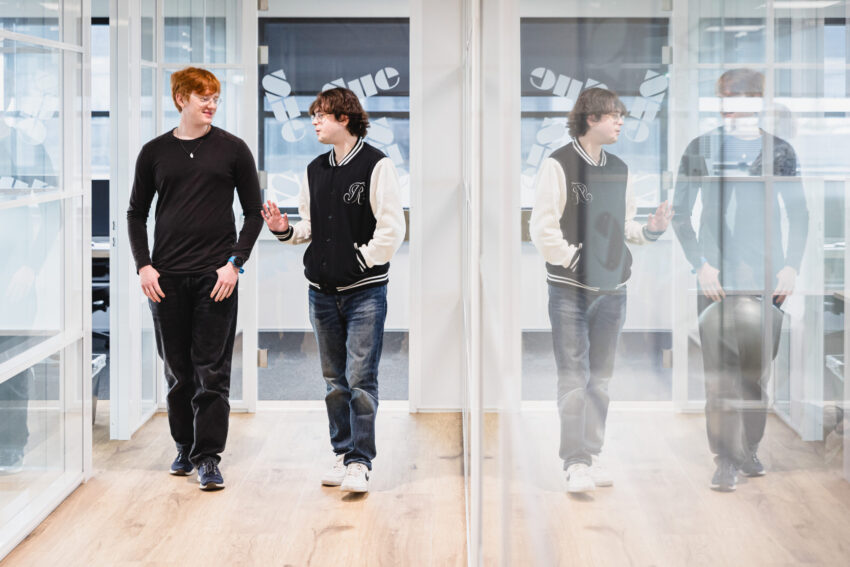 Two people walking trough the office hallway.