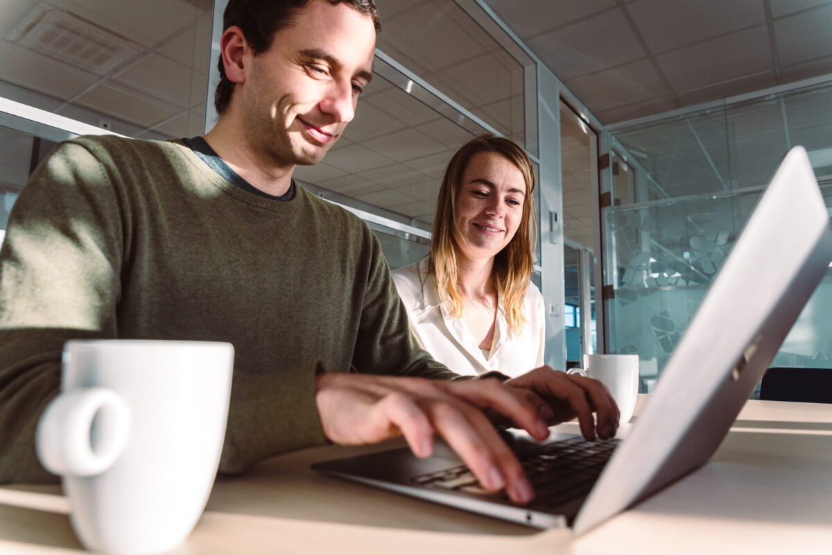 Two people behind a laptop.