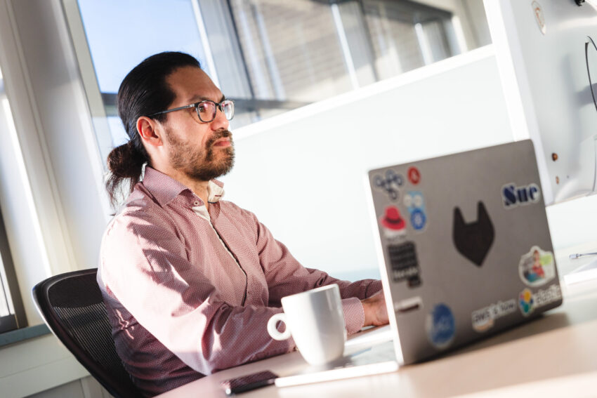A person at a desk working on a laptop.