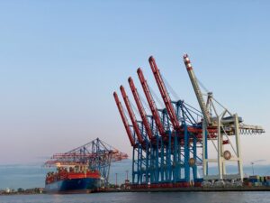 Container terminal with ship-to-shore cranes loading cargo vessels
