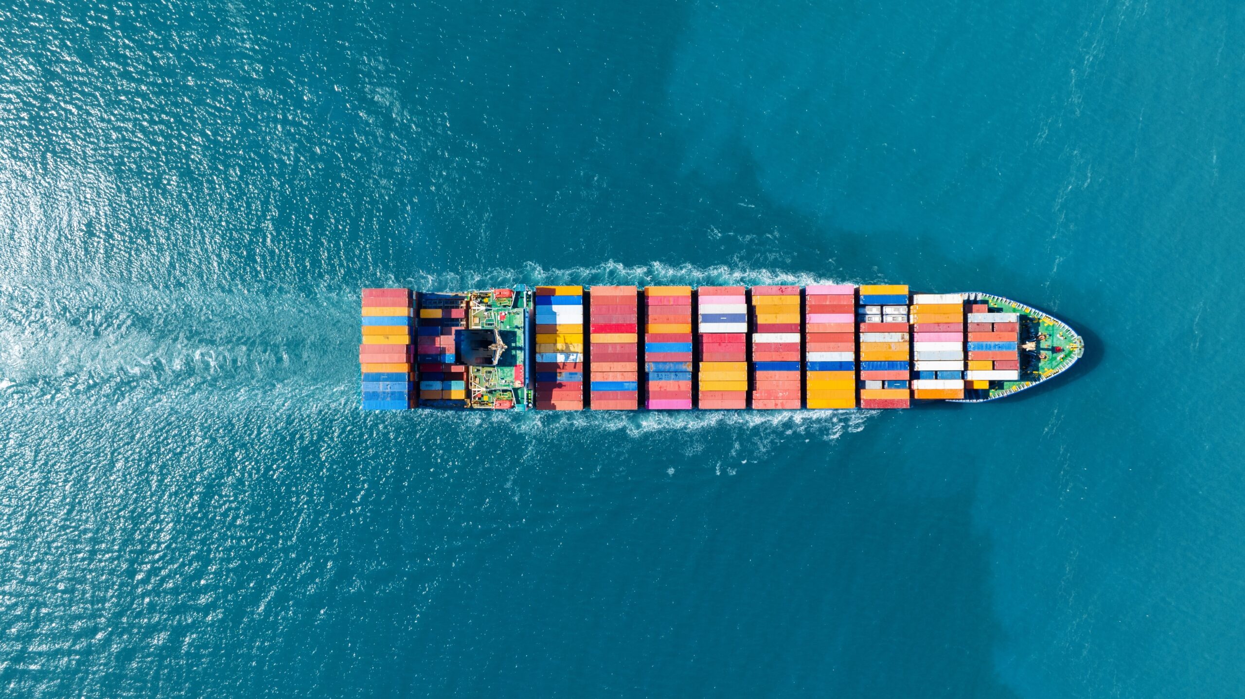 top view Cargo Container ship in the ocean ship carrying container and running for import export concept technology freight shipping by ship